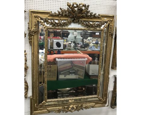 A 19th Century carved giltwood and gesso framed wall mirror, the surmount decorated with flaming torch and arrows within ribb