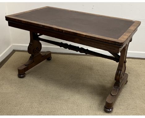 A Victorian rosewood library table, the rectangular top on end pillar supports united by a turned stretcher, bearing brass pl