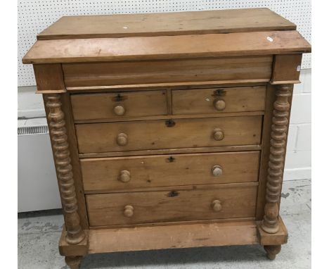 A 19th Century North Country pine chest, the canted top over a cushion drawer, two short and three long drawers, flanked by b