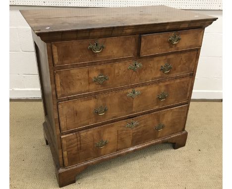 An 18th Century walnut chest, the oak and cross-banded top over two short and three long graduated cross-banded drawers, on b