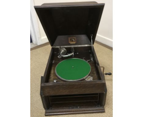 An HMV oak cased table top gramophone with caddy style cover and two doors to front