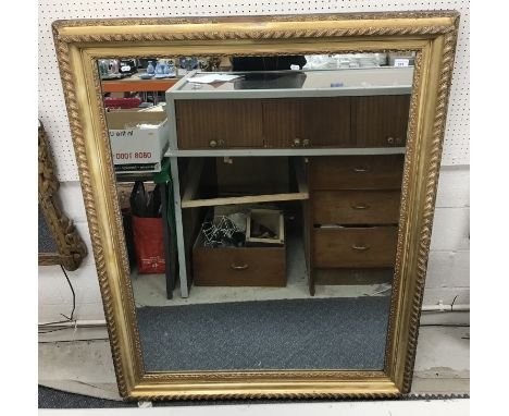 A 19th Century carved giltwood and gesso framed rectangular wall mirror with gadrooned and foliate decorated swept frame encl