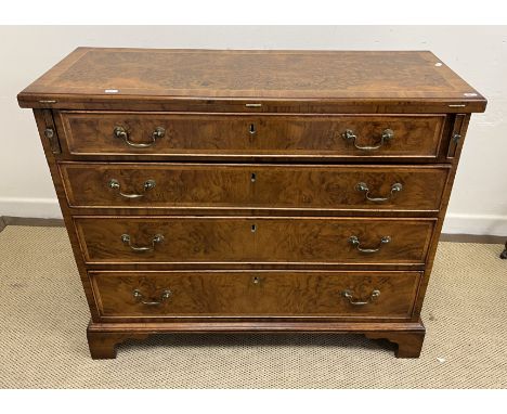 A burr walnut bachelor's chest in the early 18th Century manner, the cross banded and feather banded top with moulded edge op