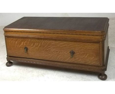 An early 20th century oak blanket chest with canted corners and long single drawer, raised on bun feet, made from the base of