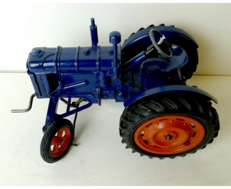 A Chad Valley Fordson Major Tractor, dark blue with orange hubs and black tyres, unboxed.