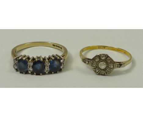 A sapphire and diamond ring, the three sapphires divided by four pairs of diamonds, platinum mounted, on a 9ct gold band, siz