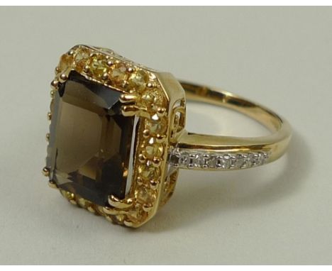 A 9ct gold smoky quartz, diamond and yellow sapphire ring, the central emerald cut smoky quartz framed by yellow sapphires, w