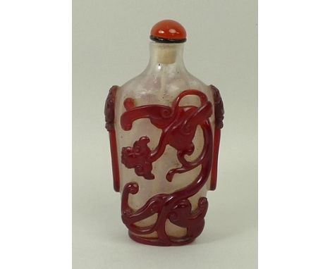 A Chinese red overlay glass snuff bottle, early 19th century, carved with two qilong dragons with bifurcated tails and mask a