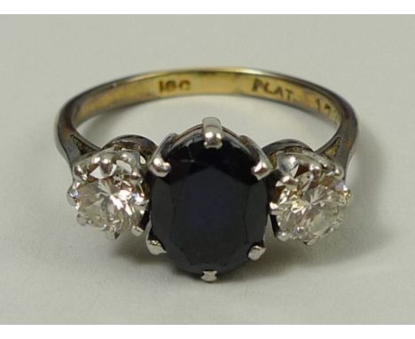 An 18ct gold, platinum, sapphire and diamond ring, the central sapphire flanked by two diamonds, diamonds approximately 0.5ct