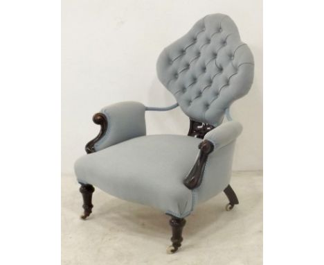 A Victorian mahogany button back chair, the quatrefoil shaped back united by outwardly curved padded arms, upholstered in lig