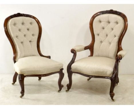 A pair of Victorian walnut spoonback chairs, ladies and gentleman's, with carved crests to the rails, upholstered in cream bu