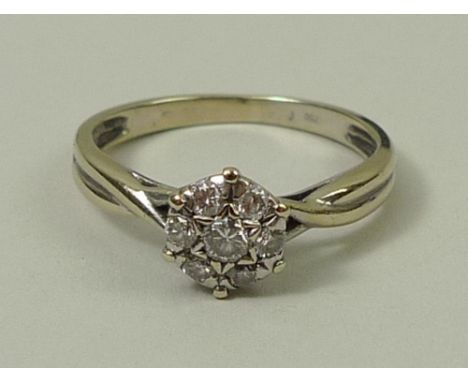An 18ct gold and diamond flower head ring with seven diamonds, set on twisted shoulders, approx 0.25cts, size L, 2.8g. 