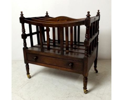 A mahogany Canterbury with three dividing rails, each corner with a turned finial, the base having a single drawer, raised on
