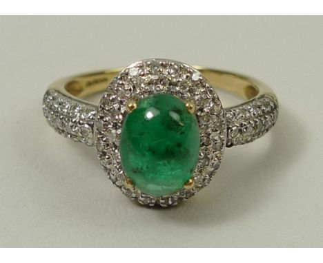 A gold, emerald and diamond ring, the central 1ct cabochon emerald surrounded by two rows of diamonds, the shoulders set with