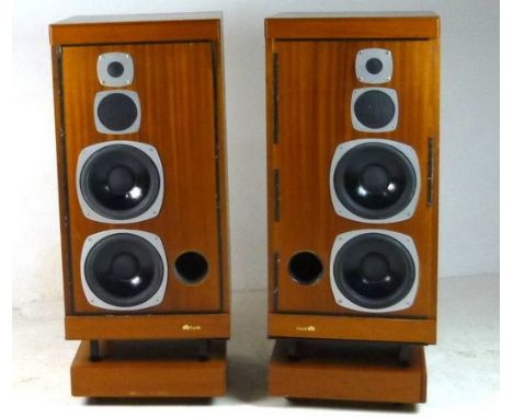 A pair of Castle teak veneered speakers with roller bases, 40 by 40 by 99cm high.