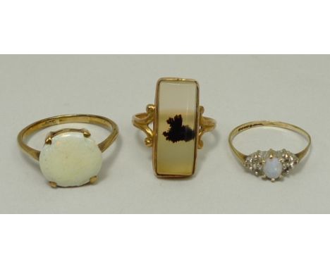 A 9ct gold and white opal set ring, size S, 9ct gold, opal and diamond ring, size L, and a 10ct gold and faux amber ring, siz