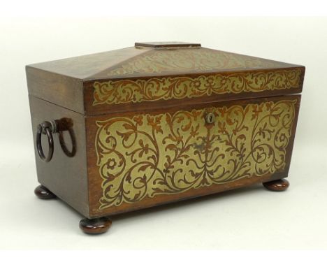 A Regency rosewood and brass inlaid tea caddy of sarcophagus form, twin ring handles, opening to reveal a mixing bowl, flanke