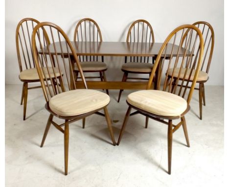 An Ercol dark stained elm dining table, 153 by 84 by 73cm high, together with a matching set of six hoop back chairs. (7)