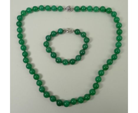 A jade bead necklace and a matching bracelet, each on an 18ct white gold snap clasp. 
