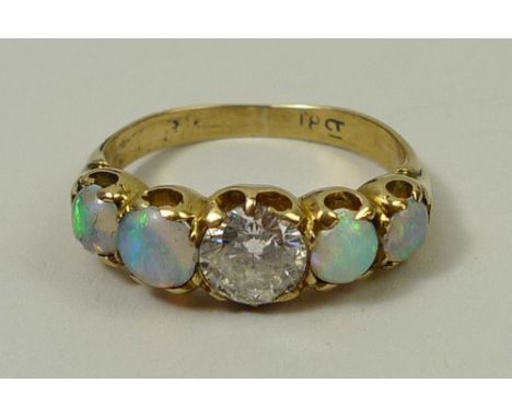 An 18ct gold, diamond and opal ring, the central diamond of approximately 0.75ct flanked by two opals on either side, size L,