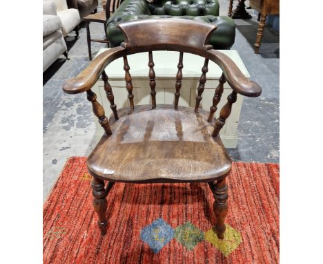 Antique stained elm/oak smokers bow armchair with ring baluster turned spindles, on baluster supports and cross stretchers