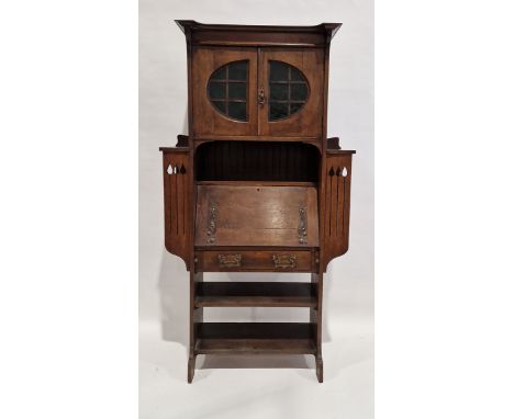 Late 19th/early 20th century Arts and Crafts oak escritoire,&nbsp;comprising a glazed two door cupboard over a single shelf, 