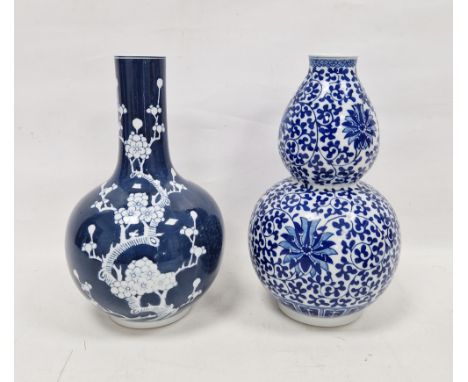 Two 20th century Chinese-style blue and white porcelain vases, first of double gourd form, decorated in the Ming style with l