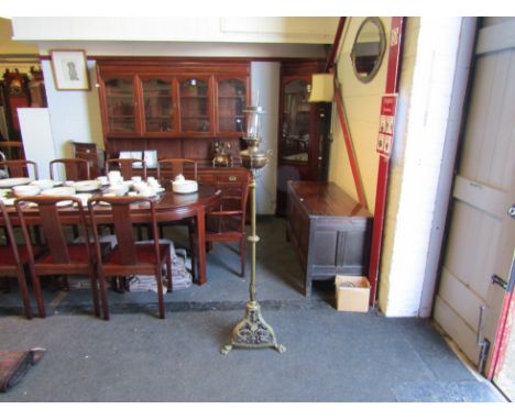 An ornate brass oil lamp stand on lion feet