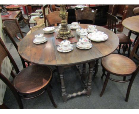 A Georgian country oak and elm gate leg dining table with bobbin-turned supports