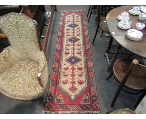 A ground runner with cream, green and blue borders with 3 central diamond lozenges and geometric design. 275cm x 71cm