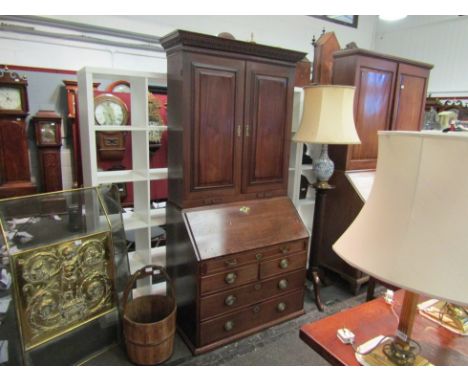 A George II bureau bookcase, the carved cornice over twin fielded panel doors opening to reveal sectional shelf-space, the ba