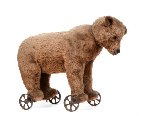 Late 19th / Early 20th Century Bear on Metal Wheels, straw filled and with boot button eyes, small hump and felt pads to feet