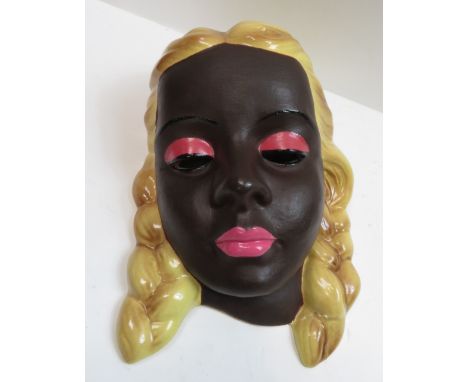 A Goldscheider style mask, modelled as a female with blonde plaits, with a black backstamp, 20cm high