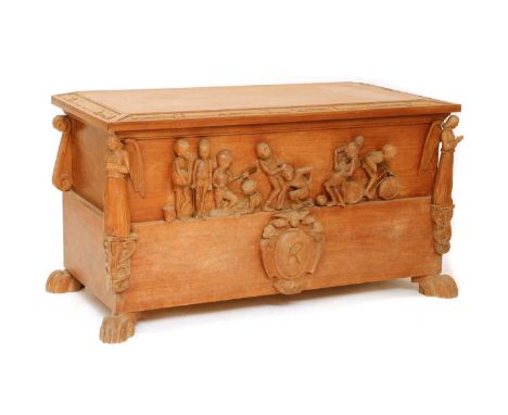 A hardwood toy trunk, c.1950-55, carved with a frieze to the front depicting boys holding a beach ball, digging with spades, 