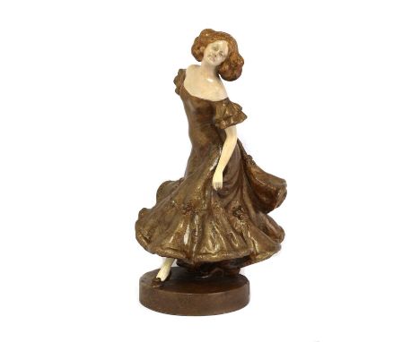 An Austrian Goldscheider figurine, c.1910, modelled as a dancer in a brown dress, surmounted on a circular base, the base imp