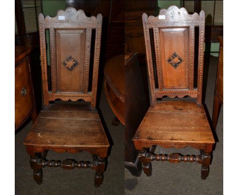 A pair of early 18th century joined oak, ebonised and parquetry decorated hall chairs, with shaped top rails above a fielded 
