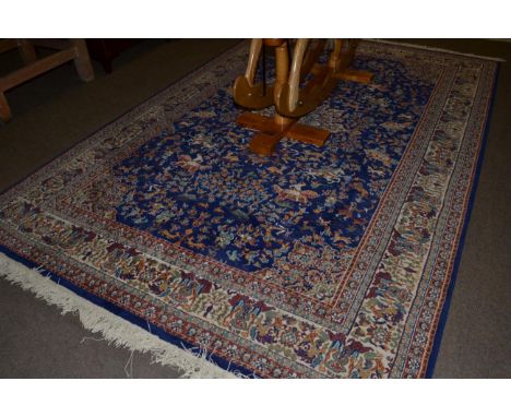 A machine made carpet of hunting design, royal blue field with central medallion framed by spandrels and ivory borders, 290cm