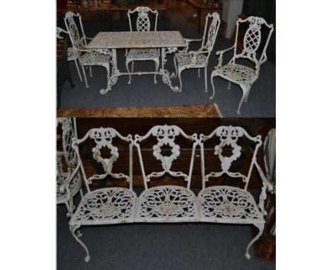 A suite of painted metal garden furniture comprising a table, four chairs and a three seater bench 