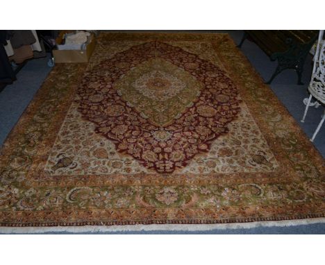 Agra design carpet, Indian, the raspberry field with vines around an olive green medallion framed by spandrels and floral bor
