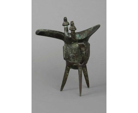 Chinesisches Bronze-Ritualgefäß "Jue" im archaischen Stil dunkel patiniert, ovoides Gefäß mit 2 Ausgüssen auf 3 schlanken Bei