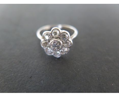 A platinum and diamond cluster ring with a central diamond surrounded by eight smaller diamonds - ring size M/N - approximate