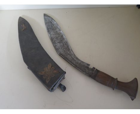 A Kukri Knife - 41cm long - some pitting and chips to blade - wear to scabbard, small knives missing - grip split and chipped