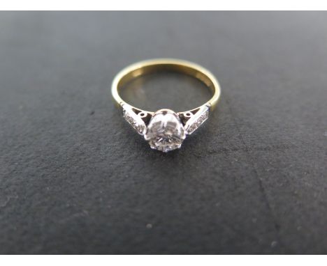 An 18ct yellow gold diamond ring size M - approximately 2 grams - the central diamond approximately 0.40ct, flanked either si