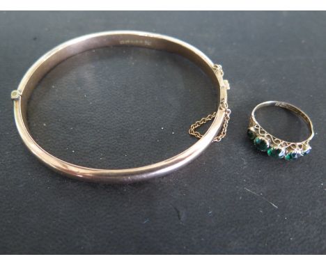 A 9ct yellow gold ring, five green stones to shoulder - size N, approx 1.4 grams and a 9ct yellow gold bangle - approx 7.2 gr