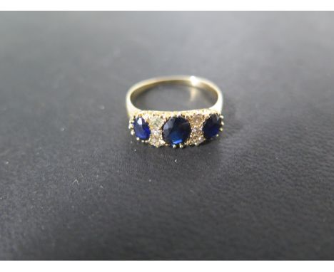 A yellow gold sapphire and diamond ring - the central sapphire approx 6mm x 5mm x 3mm deep - ring size P - approx weight 3.5 