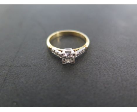 A yellow gold diamond ring - size N - approximately 3 grams - the central diamond approximately 0.24 ct - flanked either side