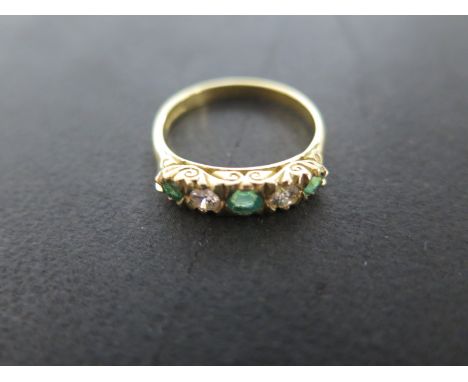 An 18ct yellow gold diamond and emerald five stone ring - size P - approximately 4.4 grams - central stone approximately 4mm 