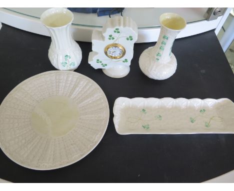Five items of Belleek - different dates and stamps - including two vases, a clock, pin-tray and plate - all items in good con