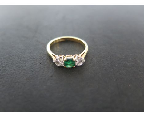 An 18ct yellow gold diamond and emerald three stone ring - size L/M - approximately 2.8 grams - emerald approximately 4mm x 4