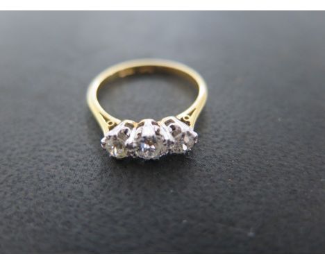 An 18ct yellow gold and platinum three stone diamond ring - size M/N - approximately 2.8 grams - central diamond approximatel